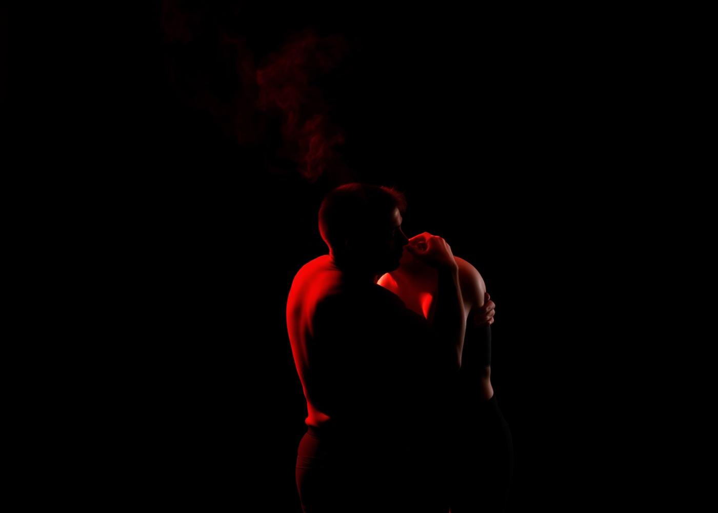 Dois atores em contato durante improvisação em luz vermelha